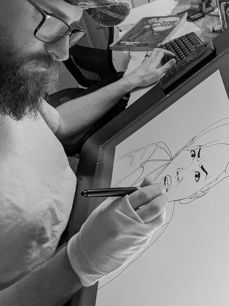 Black and white image of an artist drawing on a digital drawing tablet